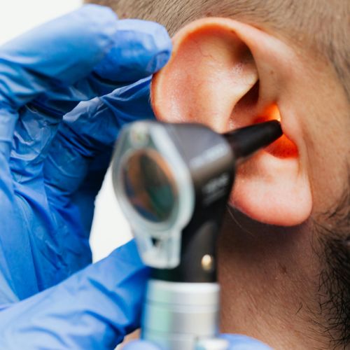 Doctor examining a patient's ear with an otoscope